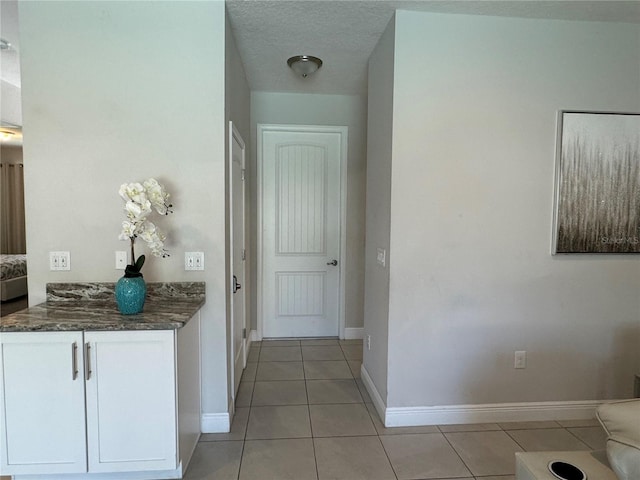 hallway featuring light tile patterned flooring and a textured ceiling