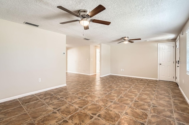 empty room with ceiling fan and a textured ceiling