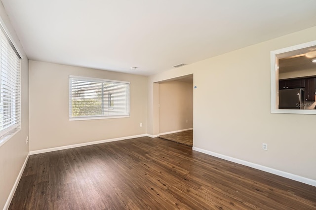 unfurnished room featuring dark hardwood / wood-style floors and a wealth of natural light