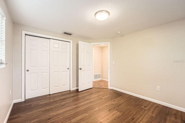 5023 Thames Dr, New Port Richey, FL 34652 - unfurnished bedroom featuring dark wood-type flooring and baseboards