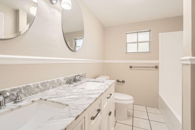 5023 Thames Dr, New Port Richey, FL 34652 - bathroom with tile patterned flooring, double vanity, and toilet