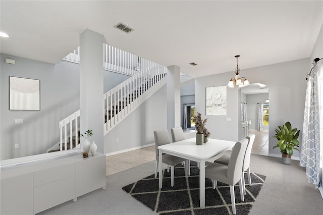 dining area featuring a chandelier and light colored carpet