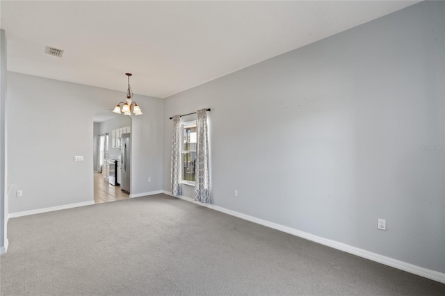 unfurnished room with a notable chandelier and light carpet