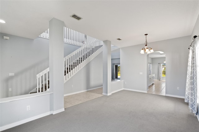 unfurnished living room with light colored carpet and a notable chandelier