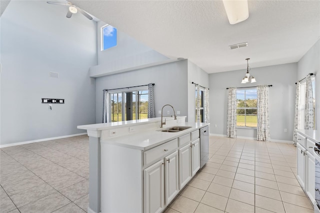 kitchen with a textured ceiling, sink, pendant lighting, dishwasher, and white cabinets