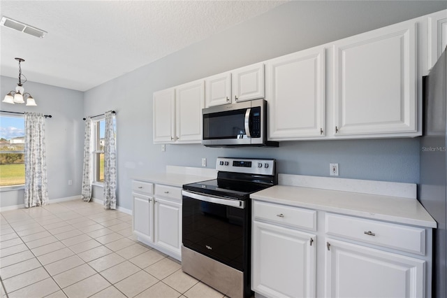 kitchen featuring decorative light fixtures, stainless steel appliances, and white cabinetry