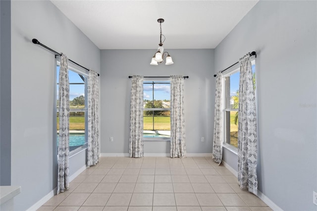 tiled empty room with an inviting chandelier