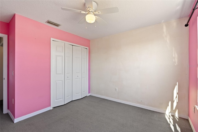 unfurnished bedroom with carpet flooring, a textured ceiling, a closet, and ceiling fan