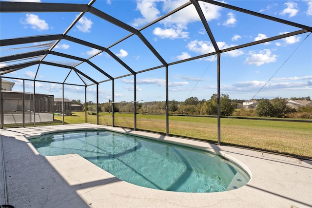 view of swimming pool with a yard, a patio, and a lanai