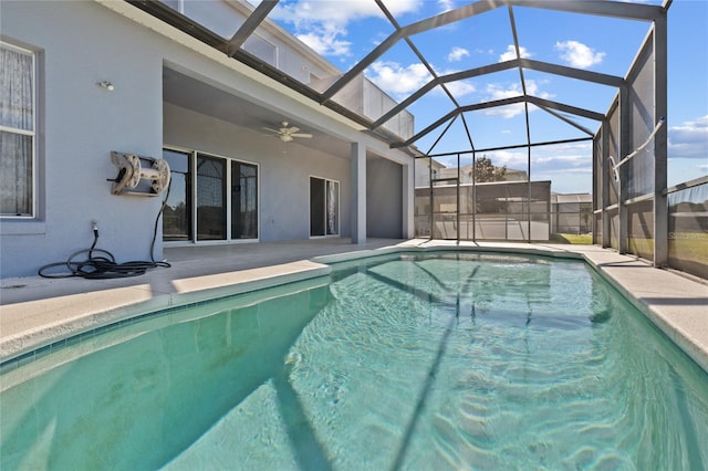 view of swimming pool featuring ceiling fan, a patio, and glass enclosure