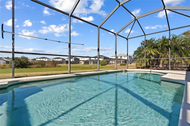 view of swimming pool with glass enclosure and a lawn