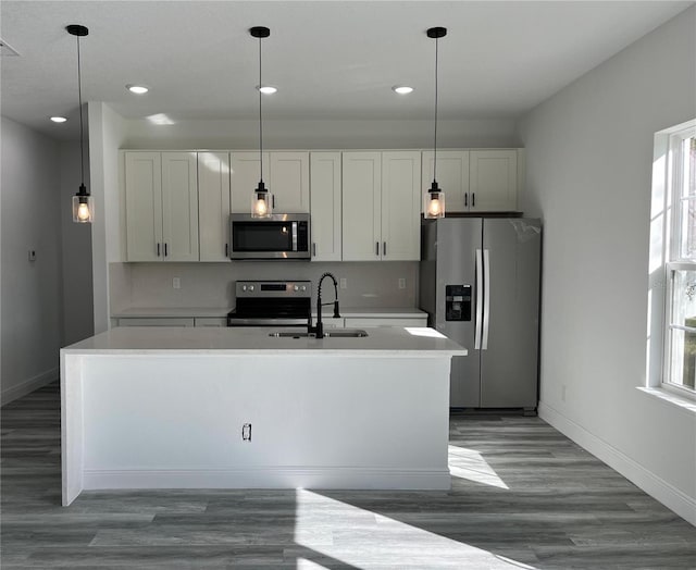 kitchen with white cabinetry, sink, hanging light fixtures, and appliances with stainless steel finishes