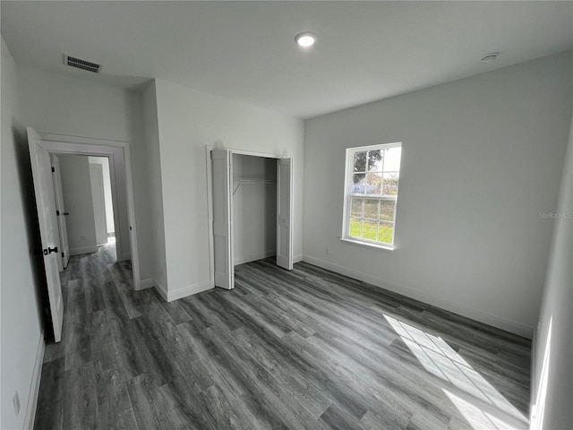 unfurnished bedroom featuring dark hardwood / wood-style floors and a closet