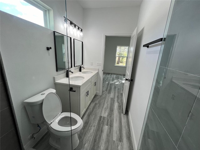 bathroom featuring wood-type flooring, vanity, toilet, and walk in shower