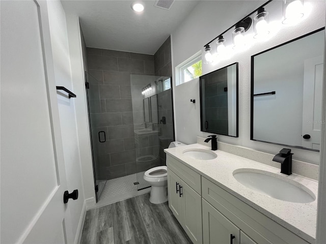 bathroom with vanity, wood-type flooring, an enclosed shower, and toilet