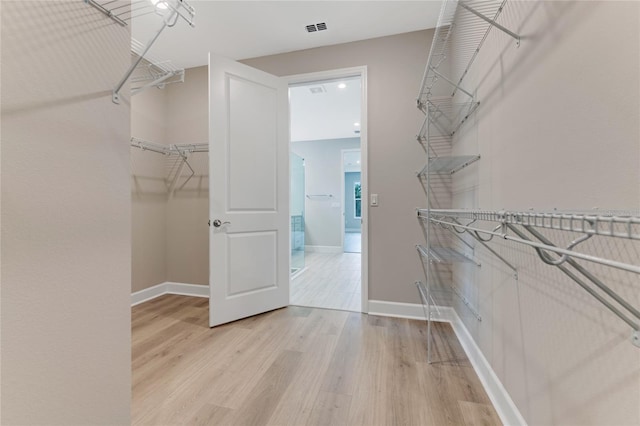 spacious closet featuring light hardwood / wood-style floors