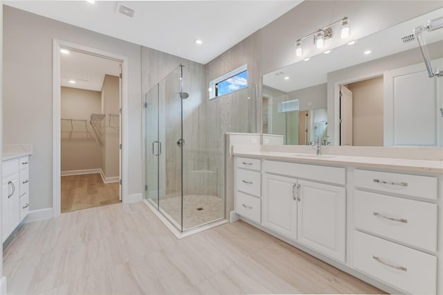 bathroom featuring vanity and a shower with door