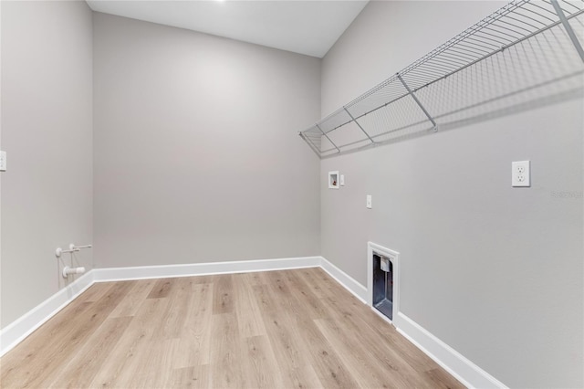 washroom with hookup for a washing machine and light wood-type flooring