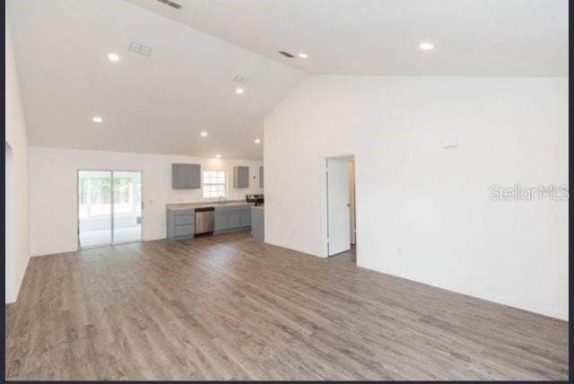 unfurnished living room with high vaulted ceiling and hardwood / wood-style flooring