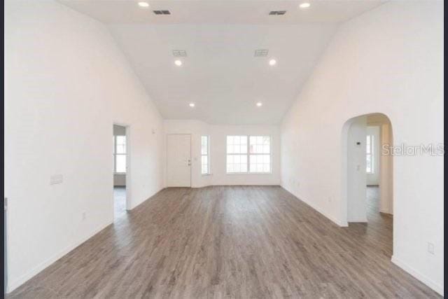 empty room with hardwood / wood-style floors and high vaulted ceiling