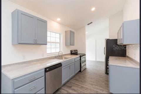 kitchen with gray cabinets, light wood-type flooring, sink, and appliances with stainless steel finishes