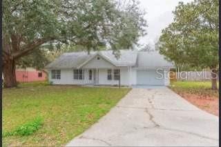 ranch-style house with a garage and a front lawn