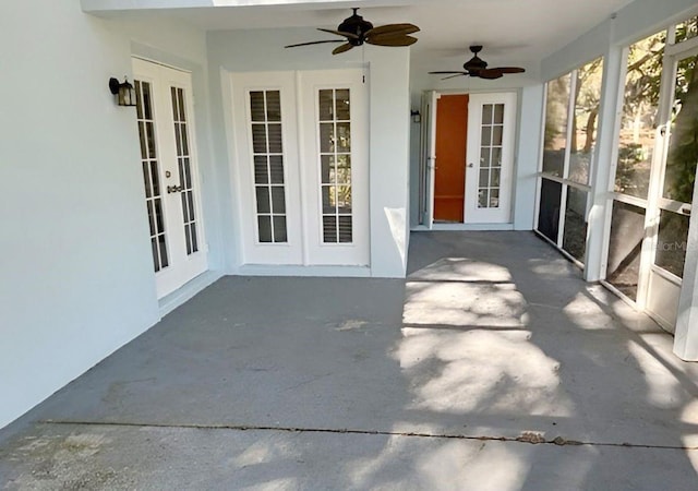 unfurnished sunroom featuring ceiling fan and french doors