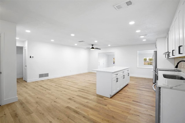 1621 Puritan, Winter Park, FL 32792 - kitchen featuring freestanding refrigerator, a sink, white cabinets, light wood-style flooring, and recessed lighting