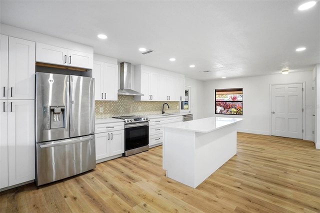 1621 Puritan, Winter Park, FL 32792 - kitchen with stainless steel appliances, wall chimney range hood, a sink, light countertops, and light wood finished floors