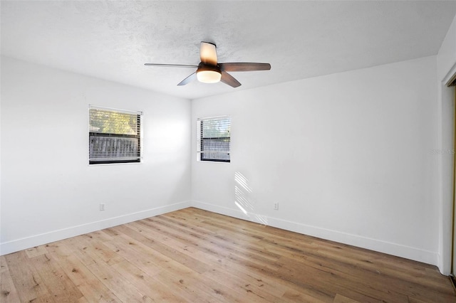 empty room with ceiling fan, light hardwood / wood-style flooring, and a textured ceiling