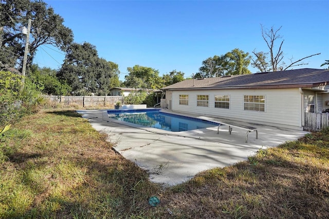 view of swimming pool featuring a diving board, a patio area, and a lawn