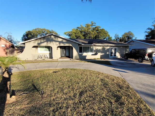 single story home featuring french doors and a front lawn