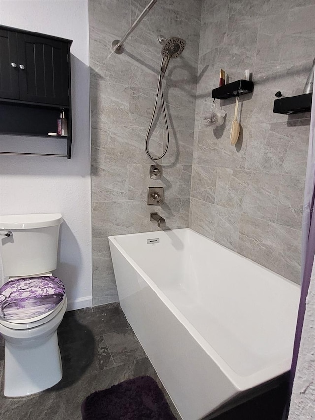 bathroom featuring tiled shower / bath combo and toilet