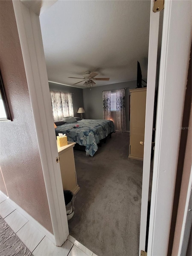 carpeted bedroom featuring multiple windows and ceiling fan