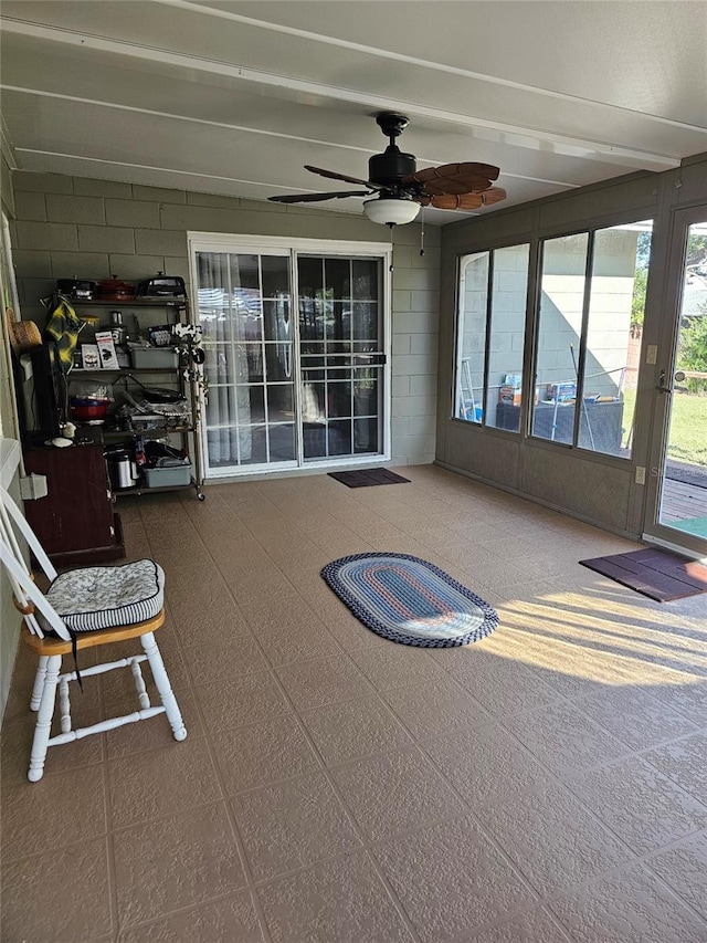 unfurnished sunroom featuring ceiling fan