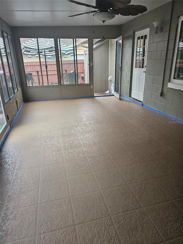 unfurnished sunroom featuring ceiling fan