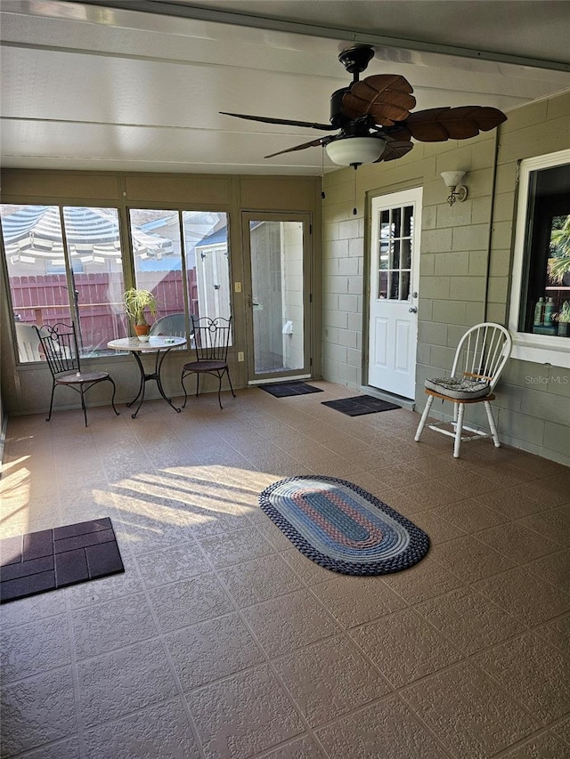 unfurnished sunroom with ceiling fan