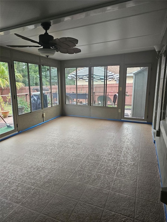 unfurnished sunroom with ceiling fan