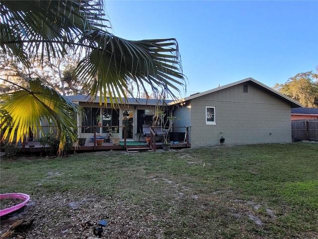 rear view of property with a deck and a yard