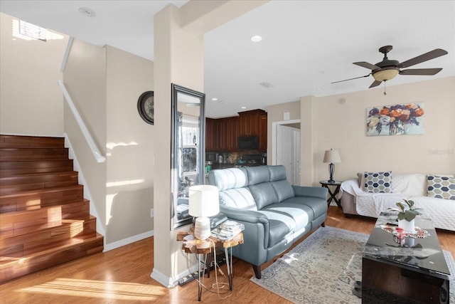 living room with ceiling fan and light hardwood / wood-style flooring