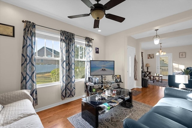 living room featuring hardwood / wood-style floors and ceiling fan with notable chandelier