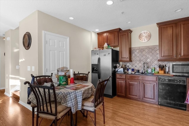 kitchen with sink, light wood-type flooring, a textured ceiling, and appliances with stainless steel finishes