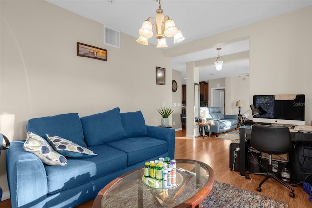 living room with wood-type flooring and an inviting chandelier