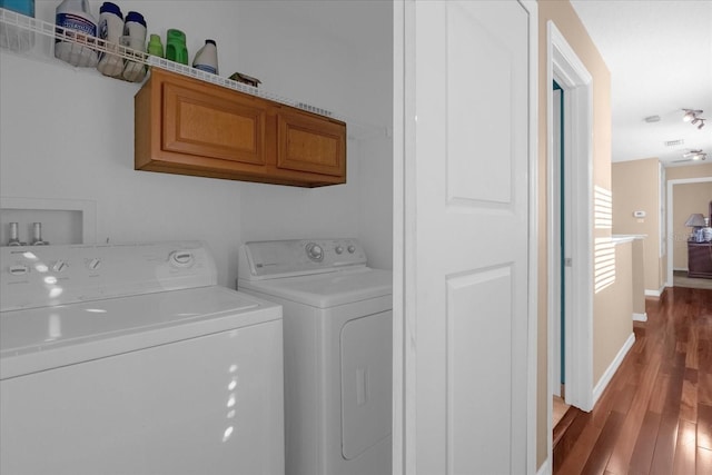 washroom featuring cabinets, independent washer and dryer, and hardwood / wood-style flooring