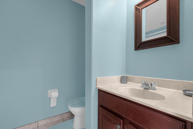 bathroom featuring tile patterned flooring, vanity, and toilet