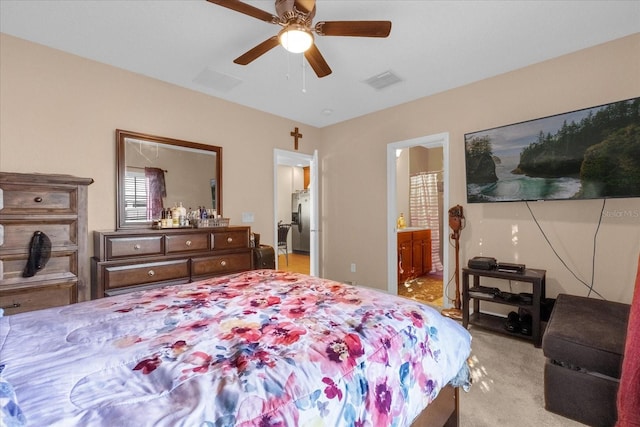 bedroom featuring stainless steel fridge, ensuite bath, ceiling fan, and light carpet