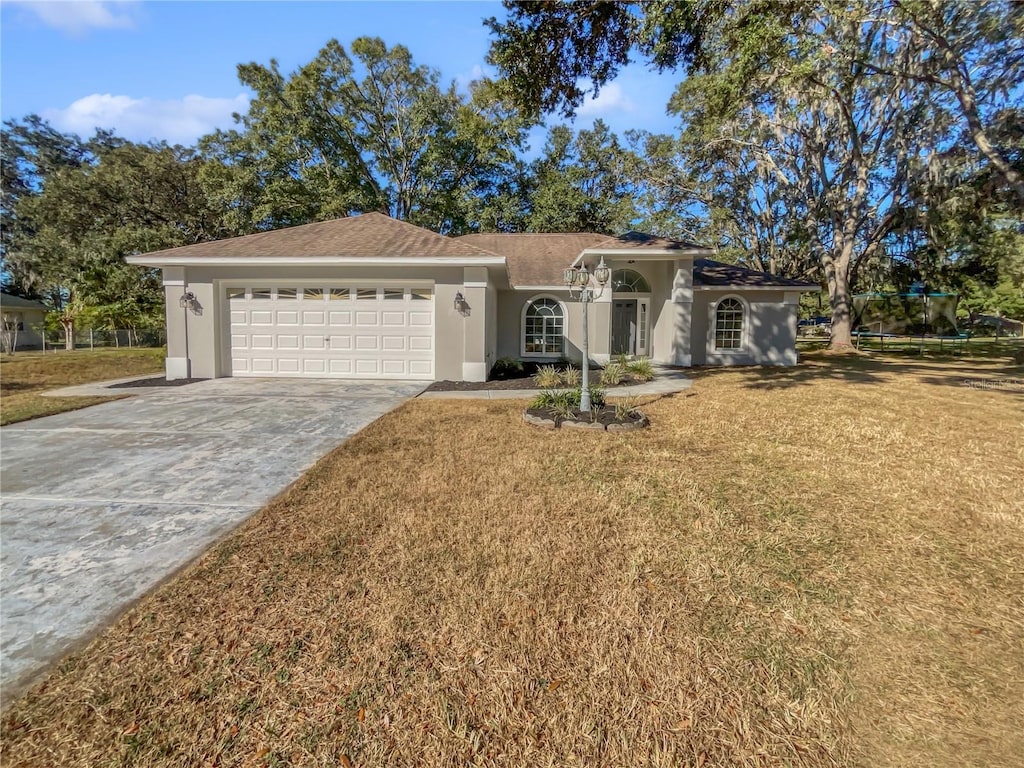 ranch-style home with a garage and a front lawn