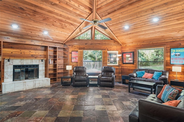 living room featuring a tiled fireplace, wood walls, and wood ceiling