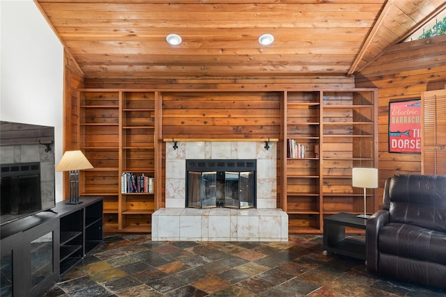 living room with a tiled fireplace, wood walls, wooden ceiling, and lofted ceiling