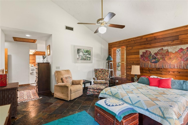 bedroom featuring ceiling fan, wooden walls, and high vaulted ceiling